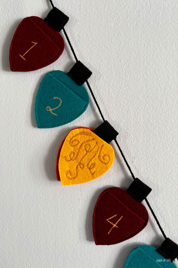 Close-up of the yellow day marker light tucked into a pocket on the DIY felt Christmas advent calendar.