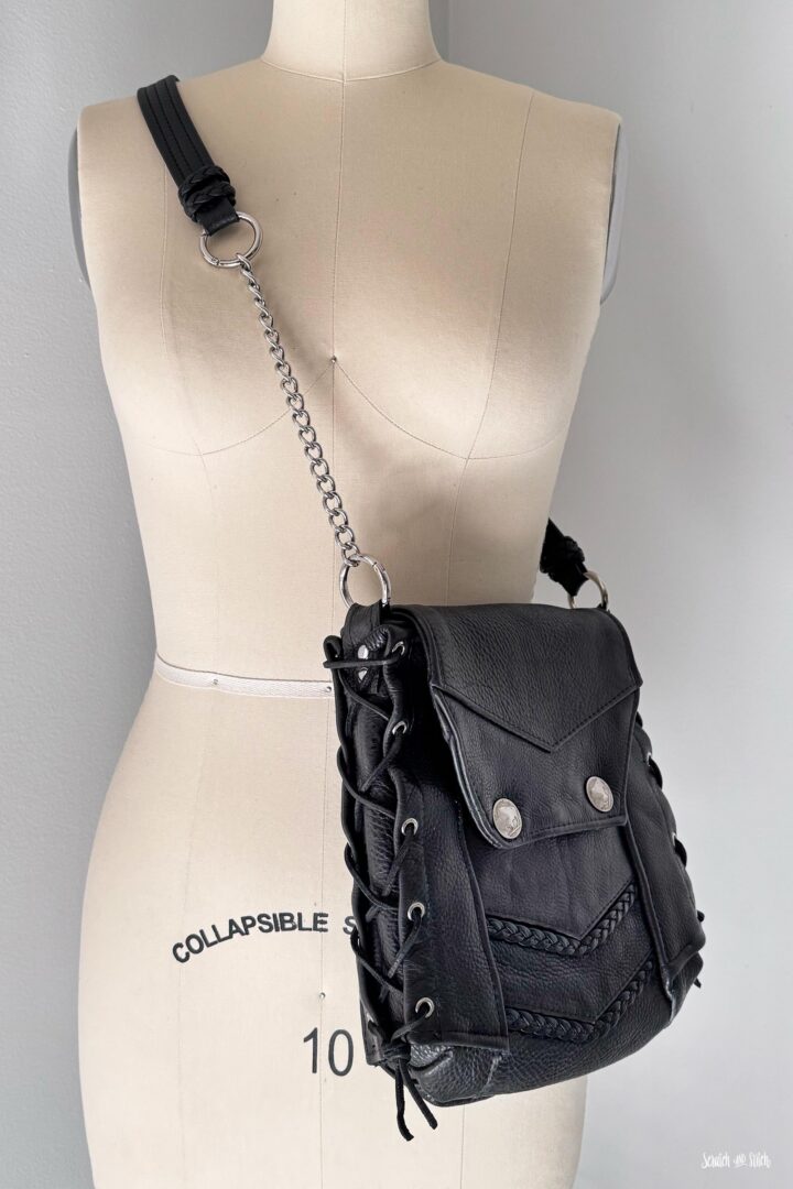 Leather biker vest crossbody bag with flap closure, braided leather accents, and original vest hardware