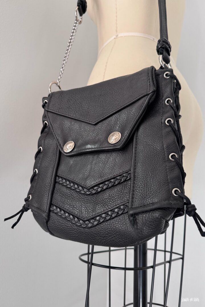 Custom leather biker vest memory bag with buffalo nickel snaps, braided leather details, and chain strap