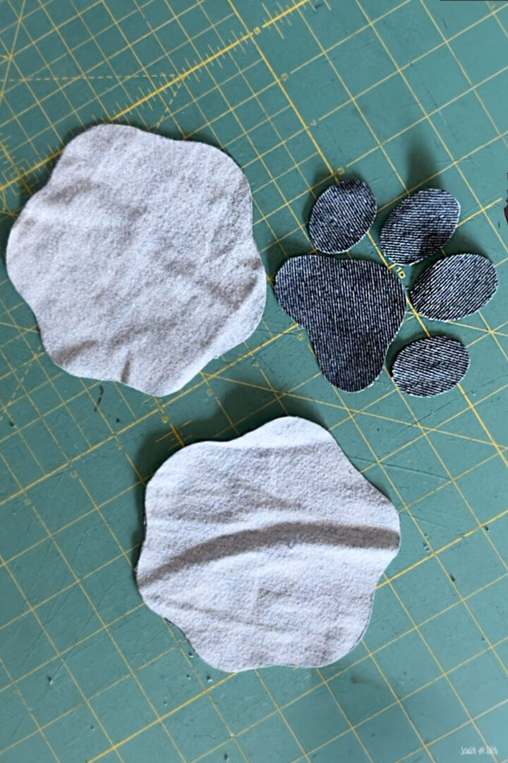 Denim base and paw print pieces cut for a fabric pattern weight